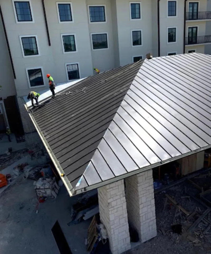 Crew installing standing seam metal roof panels on a commercial project in Holtville